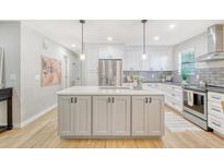 Modern kitchen featuring an island, stainless steel appliances, and gray backsplash at 112 Blue Heron Dr, Summerville, SC 29485