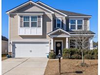 Charming two-story home featuring a two-car garage, neutral siding, and a welcoming front porch with tasteful landscaping at 1148 Flyway Rd, Summerville, SC 29483