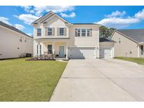 Charming two-story home with a well-manicured lawn, inviting porch, and three-car garage at 130 Wappoo Trace Ln, Summerville, SC 29486