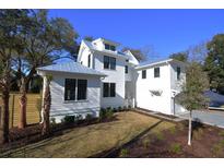 Charming two-story home with a lush lawn, metal roof, and inviting curb appeal at 1495 Pocahontas St, Mount Pleasant, SC 29464