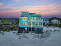 Stunning turquoise beachfront home with multi-level balconies offering panoramic sunset views and private beach access at 1699 E Ashley Ave # B, Folly Beach, SC 29439