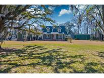 Charming two-story home with well-manicured lawn and mature trees creating a picturesque setting at 1898 Hialeah Ct, Charleston, SC 29414