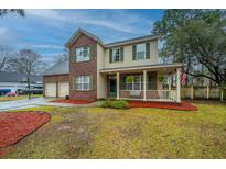 Charming two-story home with brick accents, a welcoming porch, and a well-maintained front yard at 211 Trestlewood Dr, Summerville, SC 29486