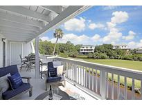 Inviting covered balcony offers seating and views of the waterway and golf course at 236 Driftwood Ln, Edisto Island, SC 29438