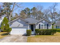 Charming single-story home featuring manicured landscaping, a two-car garage, and a welcoming front entrance at 2634 Lani Ct, Charleston, SC 29414