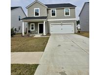 Charming two-story home with a spacious driveway, covered porch, and attached two-car garage at 290 Camellia Bloom Dr, Moncks Corner, SC 29461