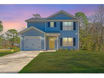 Charming two-story home with light blue siding, a well-manicured lawn, and attached garage at sunset at 3405 Painswick Rd, Johns Island, SC 29455