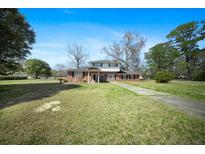 Charming two-story brick home with a spacious front yard and driveway under a bright blue sky at 1115 O T Wallace Blvd, Moncks Corner, SC 29461