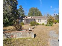 Charming one-story home with a screened-in porch and a spacious front yard at 1200 Old Mill Rd, Saint Stephen, SC 29479