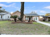 Charming brick home with manicured lawn, beautiful landscaping, and a light blue door at 1393 Secessionville Rd, James Island, SC 29412