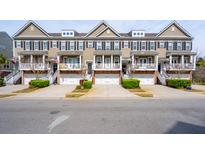 Attractive townhomes feature individual garages and covered front porches, creating inviting curb appeal at 1930 Carolina Towne Ct, Mount Pleasant, SC 29464