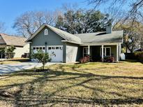 Charming single-story home features a two-car garage, covered porch, and well-maintained lawn at 1975 Trimbleston Pl, Mount Pleasant, SC 29464