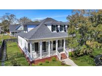 Charming home featuring a welcoming front porch, black shutters, and beautifully landscaped yard at 2028 Ironstone Aly, Charleston, SC 29407