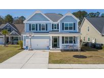 Charming two-story home with light blue siding, white trim and a well-manicured lawn at 221 Waning Way, Charleston, SC 29492