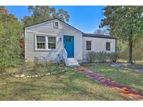 Charming single-story home with white siding, blue door and brick walkway at 2379 Sorentrue Ave, North Charleston, SC 29405