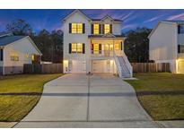 Charming two-story home with a well-manicured lawn and long driveway, perfect for a growing Gathering at 3025 Penny Ln, Johns Island, SC 29455