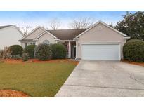 Charming single-story home with a well-manicured lawn, an attached garage and mature landscaping at 3244 Hunters Rest Drive Dr, Charleston, SC 29414
