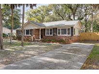 Charming brick home with a well-manicured lawn and mature trees at 3501 Hartnett Blvd, Isle of Palms, SC 29451