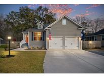 Charming two-story home features a two-car garage, well-manicured lawn and a cozy, inviting atmosphere at sunset at 3541 Walter Dr, Johns Island, SC 29455