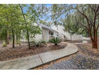 Charming home exterior with lush landscaping and a winding walkway leading to the entrance at 626 Double Eagle Trce, Johns Island, SC 29455