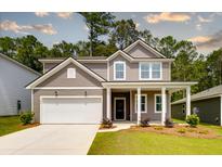 Charming two-story home featuring a covered porch, two-car garage and a well-maintained lawn at 743 Meadowbrook Ln, Summerville, SC 29486