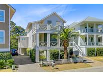 Charming, multi-story beach home featuring a quaint white picket fence, landscaped yard and cross beam railings at 744 Gate Post Dr, Mount Pleasant, SC 29464
