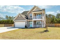 Charming two-story home featuring a welcoming porch, second story balcony, and a well-maintained front yard at 126 Lakelyn Rd, Moncks Corner, SC 29461