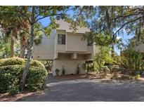 Inviting raised beach home featuring neutral siding and lush landscaping at 1409 Dune Loft Villas, Seabrook Island, SC 29455