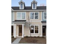 Charming townhouse featuring a black roof, dormer windows, and a light beige exterior with a covered entry at 143 Cantona Dr, Summerville, SC 29483