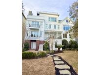 Stunning multi-story white home featuring dual balconies, meticulous landscaping, and a charming stepping stone walkway at 172 Mary Ellen Dr, Charleston, SC 29403