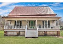 Charming two-story home featuring a large front porch, green door and a distinctive red metal roof at 242 Weathers Farm Rd, Bowman, SC 29018