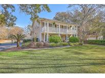 Charming two-story home with a double porch, green lawn and inviting curb appeal at 4462 Francis Yonge Way, Hollywood, SC 29449