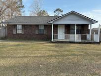 Charming single-story brick house with a welcoming front porch and a well-maintained front yard at 521 Savannah Rd, Ladson, SC 29456