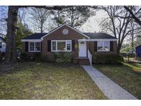 Charming brick home with a well-manicured lawn, classic design, and inviting front entrance at 5468 W Lakeland Dr, North Charleston, SC 29406