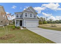 Charming two-story home with a well-manicured lawn and a two-car garage at 707 Alma Square Dr, Moncks Corner, SC 29461