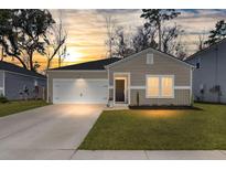 Charming one-story home featuring a well-maintained lawn and an attached two-car garage at 749 Jancus St, Charleston, SC 29414