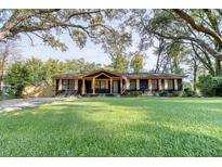 Charming single-story home features a beautifully manicured lawn, a dark brick facade, and light stained wood accents at 841 Fred St, Charleston, SC 29412