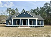 Charming single-story home with dark siding, white trim, shutters, and a welcoming front porch at 85 Prestwick Pl, Walterboro, SC 29488