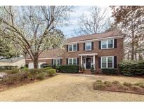 Charming two-story brick home featuring a well-manicured lawn and a lovely flowering tree in the front yard at 874 Law Ln, Mount Pleasant, SC 29464