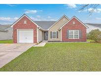 Charming single-story home featuring a manicured lawn, attached garage, and inviting brick accents at 99 Dovetail Cir, Summerville, SC 29483