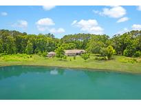 Stunning exterior view of home, featuring a serene pond and lush greenery at 1420 Polly Point Rd, Wadmalaw Island, SC 29487