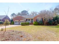 Charming brick home featuring an attached two-car garage and well-manicured lawn at 1447 Simmons St, Mount Pleasant, SC 29464
