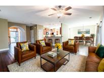 Inviting living room with hardwood floors, stylish leather seating, and an open concept to the kitchen and dining area at 173 Cypress Forest Dr, Moncks Corner, SC 29461
