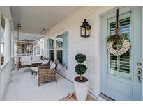 Inviting front porch featuring a swing, seating, stylish decor, and charming blue door at 1756 Timmons St, Mount Pleasant, SC 29466