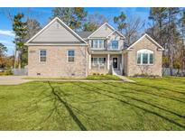 Charming two-story home with a well-manicured lawn and appealing brick and vinyl siding at 1880 Bacons Bridge Rd, Summerville, SC 29485