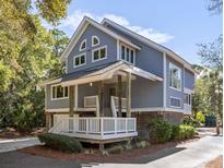Charming coastal home featuring a elevated porch, gray siding, and ample windows for natural light at 2202 Oyster Catcher Ct, Seabrook Island, SC 29455
