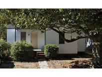 Cozy single-story home with white siding, complemented by lush landscaping and mature trees at 2326 Kent Ave, North Charleston, SC 29405