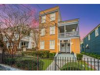 Charming yellow two-story home with a welcoming front porch and wrought iron fence at 234 Rutledge Ave # C, Charleston, SC 29403