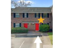 Brick townhouse featuring red doors and manicured landscaping at 2362 Parsonage Rd # 2G, Charleston, SC 29414