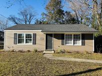 Charming single-story home featuring tan siding, black shutters, and a well-maintained front yard at 2805 Martha Drive Dr, North Charleston, SC 29405